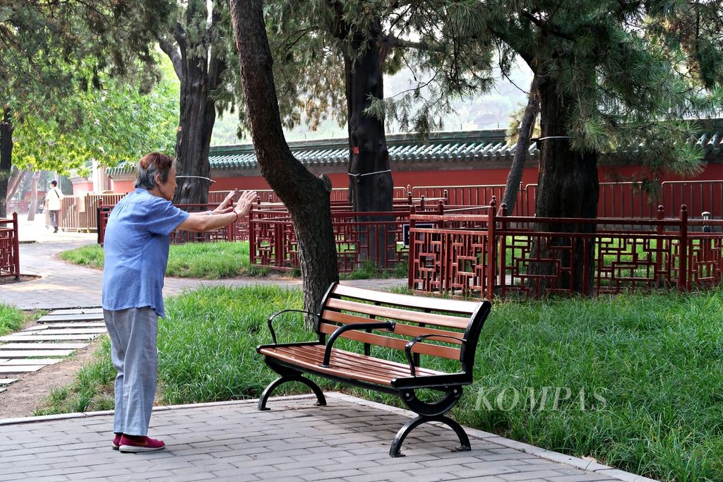 Seorang warga lansia perempuan menghabiskan pagi dengan berolahraga di kawasan Taman Ritan (Ritan Park) atau Kuil Matahari (The Temple of The Sun) di Distrik Chaoyang, Beijing, China, Minggu (25/6/2023). 