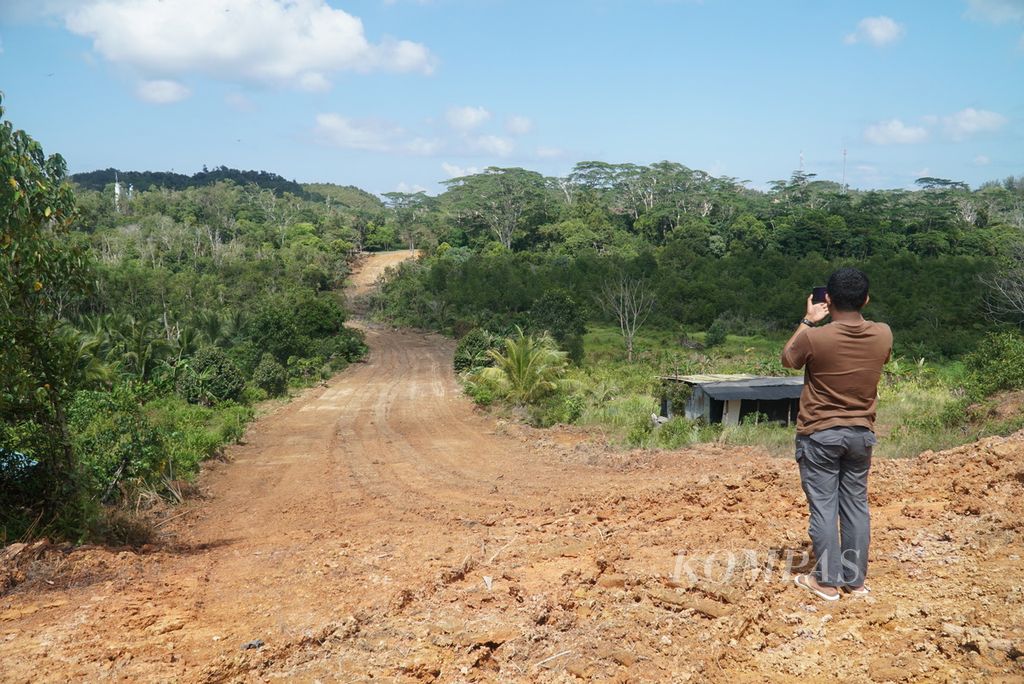 Residents are taking photos of the newly opened road in the Dapur 3 area of Galang Island, which will become the relocation site for four old villages impacted by investments on Rempang Island, Batam City, Riau Islands on Tuesday (19/9/2023). The promised type 45 houses worth IDR 120 million and 500 square meter land for affected residents have not taken shape yet as they are still to be built.