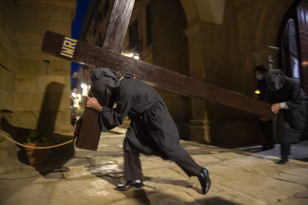 A penitent with a rope tied around the neck bears a cross during the 'El Ensogado' (The roped) procession on Easter Holy Week's Maundy Thursday in the northern Spanish village of Sietamo on April 14, 2022. - Christian believers around the world mark the Holy Week of Easter in celebration of the crucifixion and resurrection of Jesus Christ.