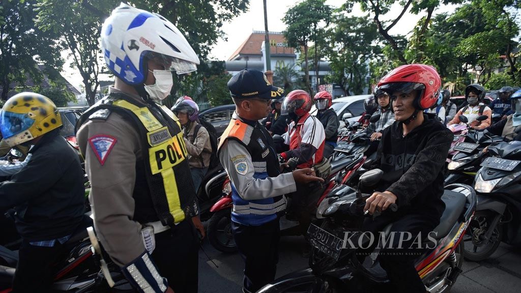 Petugas melakukan sosialisasi UU 22 Tahun 2009 dan Peraturan Menteri Perhubungan RI Nomor PM 12 Tahun 2019 Pasal 6 di Jalan Darmo, Surabaya, Selasa (9/4/2019). Peraturan tersebut tentang Perlindungan Keselamatan Pengguna Sepeda Motor yang Digunakan untuk Kepentingan Masyarakat menyertakan bahwa pengendara dilarang merokok selama berkendara. Bagi pelanggar dapat dipidana dengan kurungan paling lama tiga bulan dan denda paling banyak Rp 750.000.