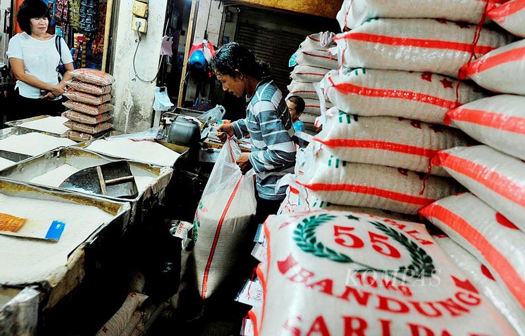 Pekerja mengemas beras dalam kantong di salah satu kios Pasar Tomang Barat, Grogol Petamburan, Jakarta Barat, Senin (31/7). Pembahasan mengenai beras sedang berlangsung, yang melibatkan pemerintah dan pemangku kepentingan. 