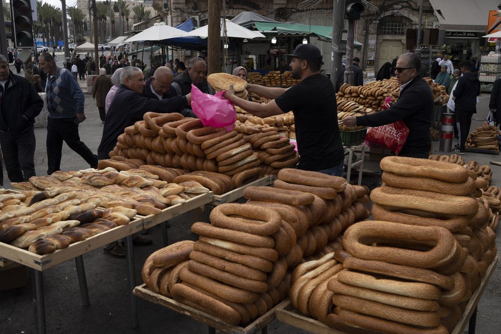 Warga membeli roti setelah menunaikan shalat di Masjid Al-Aqsa pada bulan Ramadhan di Kota Tua Jerusalem Timur pada 15 Maret 2024. 