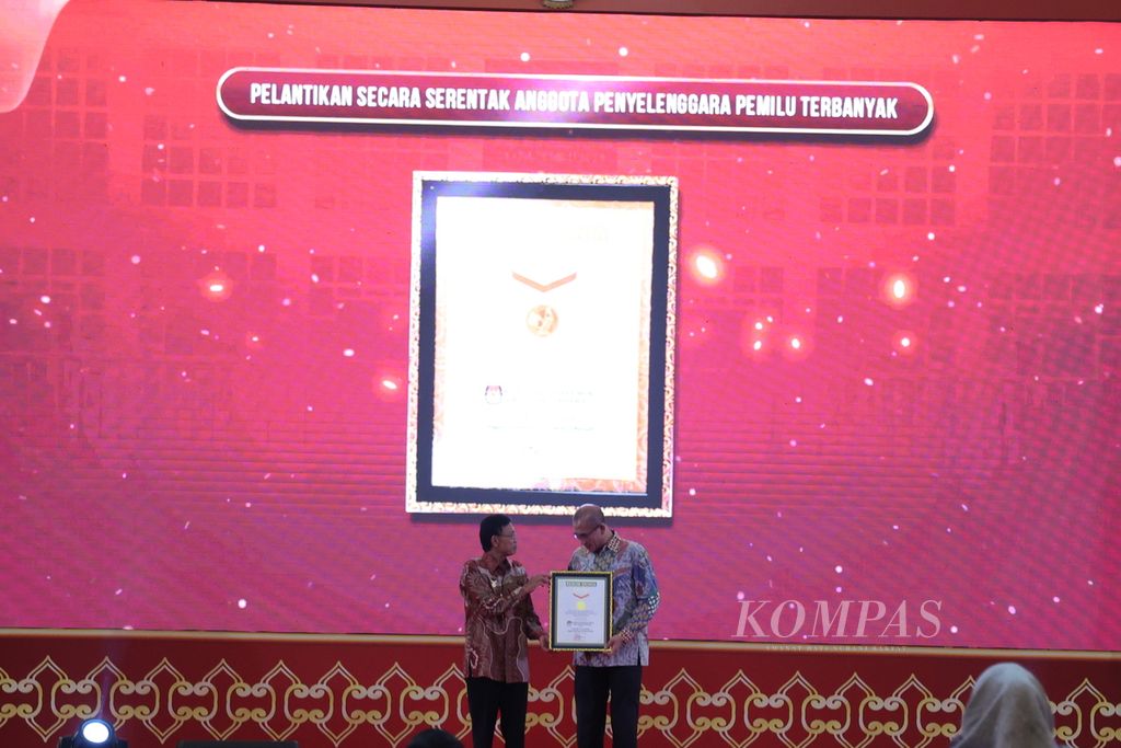 Ketua Komisi Pemilihan Umum (KPU) Hasyim Asyari (kanan) menerima penghargaan dari Museum Rekor-Dunia Indonesia atas pelantikan anggota Kelompok Penyelenggara Pemungutan Suara (KPPS) secara serentak, di Jakarta, Kamis (25/1/2024). KPU melantik 5.741.127 anggota KPPS yang bertugas di 820.161 tempat pemungutan suara (TPS). Pelantikan secara serentak ini memperoleh penghargaan dari MURI. 