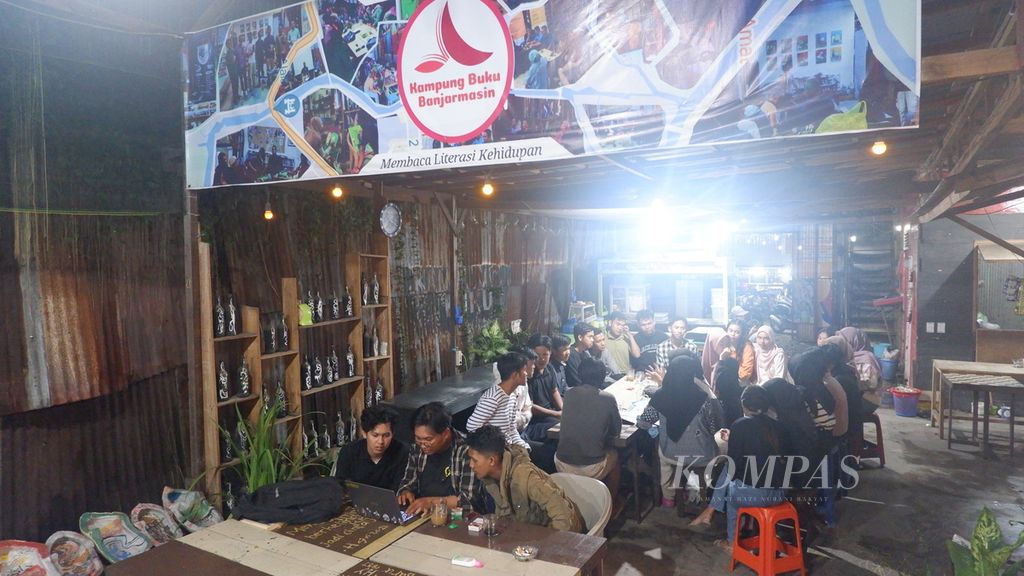 Sejumlah anak muda berkumpul di Kampung Buku Banjarmasin, Kalimantan Selatan, Rabu (10/1/2024) malam. Kampung buku tersebut menghidupkan gerakan literasi dan menjadi ruang alternatif untuk belajar, berdiskusi, berkesenian, mencari informasi, hingga menggelar pameran.
