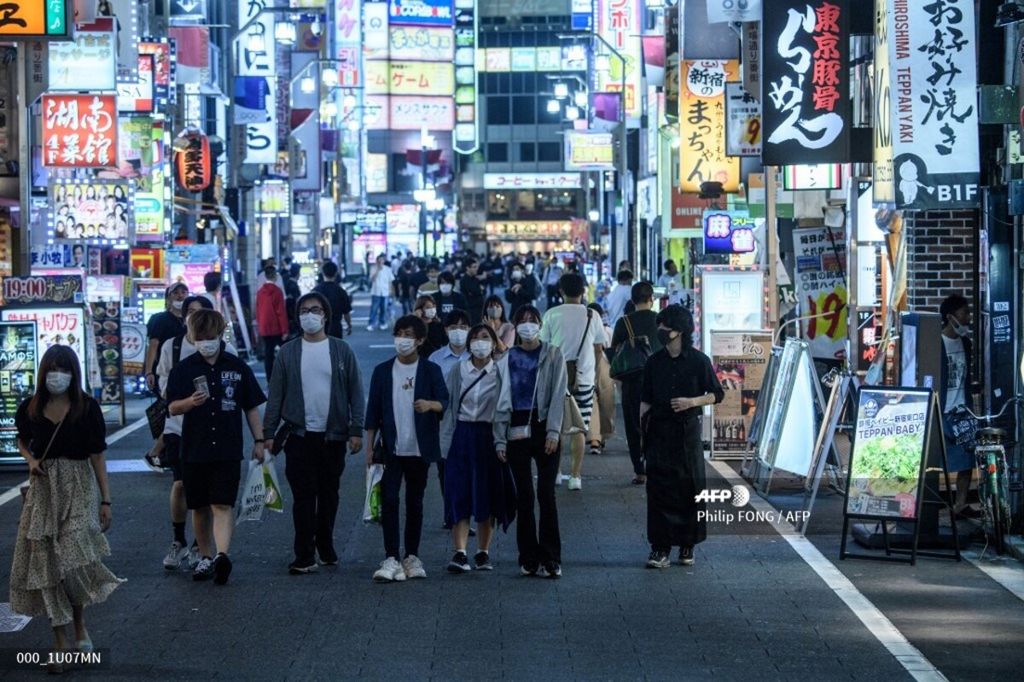 Orang-orang mengenakan masker ketika berjalan-jalan di Distrik Kabuki-Cho, Tokyo, Jepang, 24 Juni 2020.