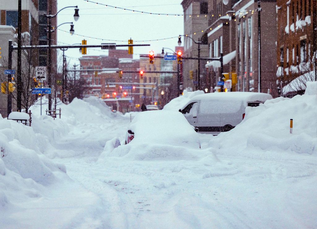 Mobil terjebak salju di pusat kota Buffalo, New York, 26 Desember 2022. Pendinginan ekstrem dan badai salju hebat kini menggantikan berita gelombang panas, yang menjadi topik pemberitaan pertengahan 2022. 