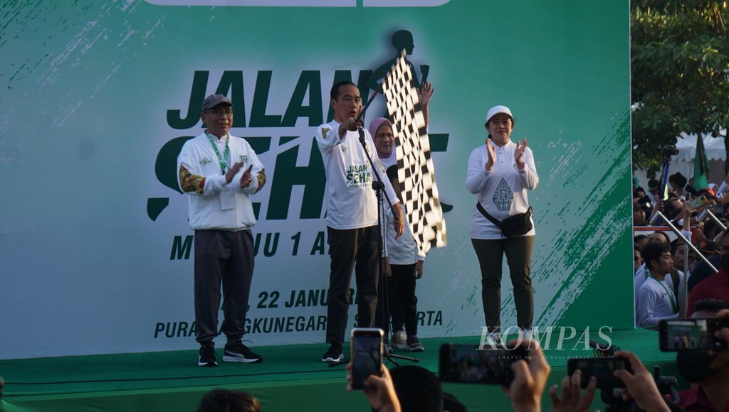 Presiden Joko Widodo (kedua dari kiri) melepas keberangkatan peserta jalan sehat jelang peringatan satu abad berdirinya Pengurus Besar Nahdlatul Ulama di Kota Surakarta, Jawa Tengah, Minggu (22/1/2023). 