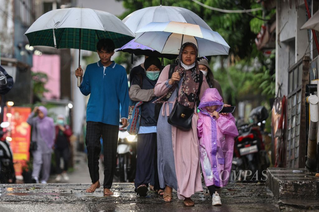 Sejumlah warga menggunakan payung saat berjalan di Jalan Margonda, Kota Depok, Jawa Barat, Sabtu (13/1/2024). Hujan deras disertai petir mengguyur Kota Depok pada Sabtu sore. Kilat yang menyambar-nyambar membuat sejumlah warga memilih untuk berteduh di sejumlah pertokoan. Badan Meteorologi, Klimatologi, dan Geofisika memprediksi Kota Depok akan diguyur hujan pada siang hingga malam hari. 