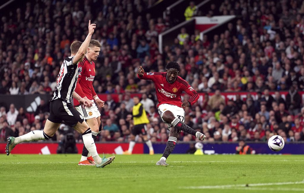 Pemain Manchester United Kobbie Mainoo (kanan) menendang bola untuk mencetak gol ke gawang Newcastle United pada laga Liga Inggris di Stadion Old Trafford, Manchester, Inggris, Kamis (16/5/2024) dini hari WIB. MU menang 3-2 pada laga itu.