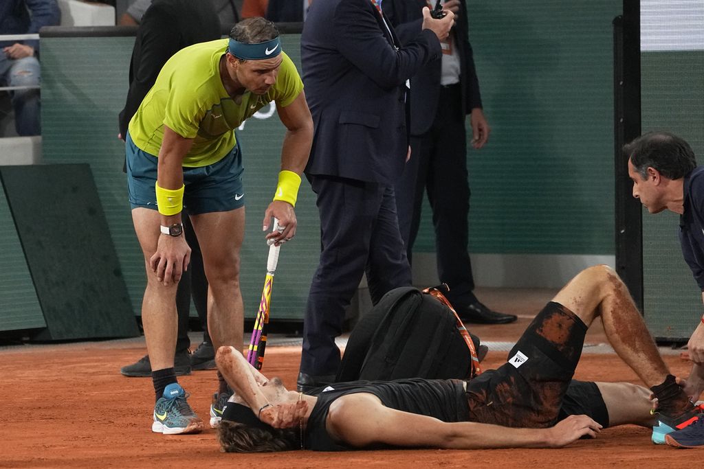 Petenis Spanyol, Rafael Nadal, melihat kondisi petenis Jerman, Alexander Zverev, yang mengalami cedera ligamen saat pertandingan semifinal Perancis Terbuka di Roland Garros, Paris, Jumat (3/6/2022). Pertandingan dihentikan pada set kedua setelah Zverev tidak mampu bertanding karena cedera parah.