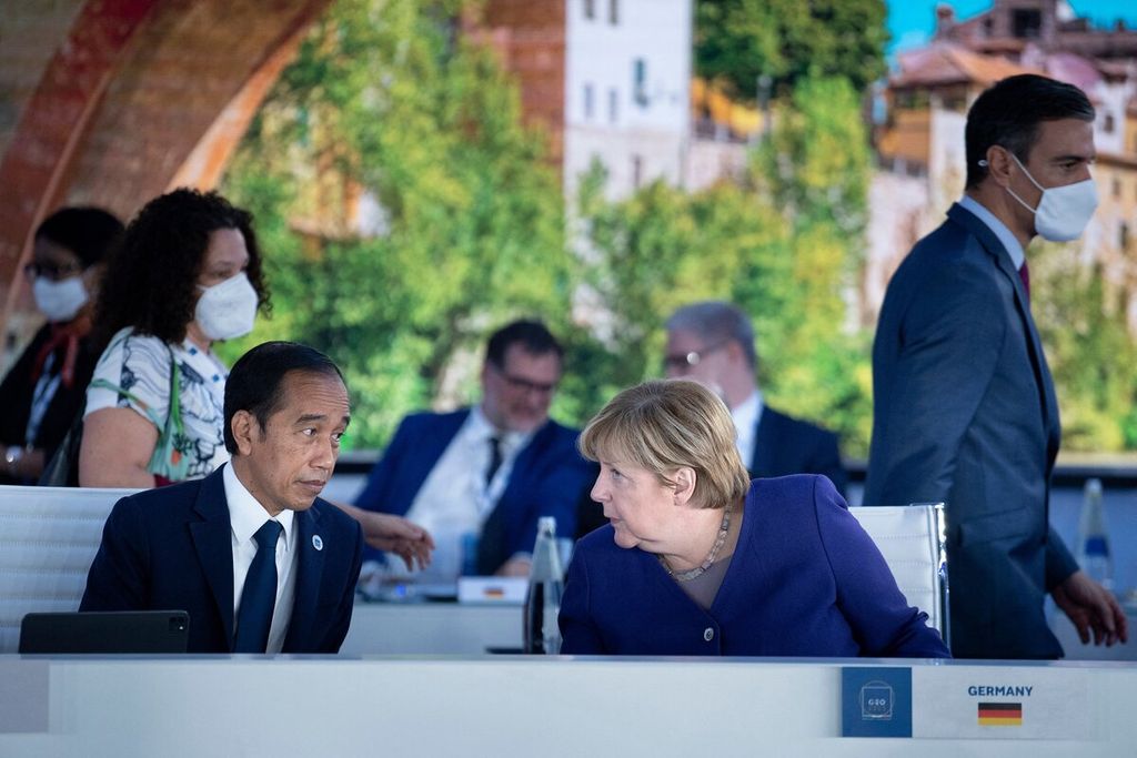 Presiden Joko Widodo dan Kanselir Jerman Angela Merkel berdiskusi sebelum pertemuan tentang rantai pasokan global dalam KTT G-20 di Roma, Italia, Minggu (31/10/2021).