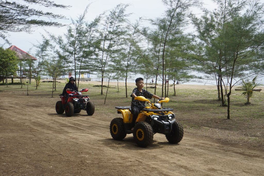 Pengunjung mengendarai motor ATV di tepi Pantai Lamaru, Kota Balikpapan, Kalimantan Timur, Minggu (15/1/2023).