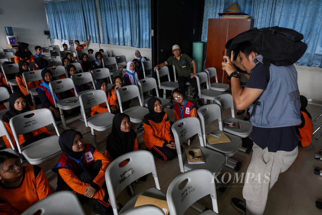 Seorang instruktur mengajarkan cara melindungi kepala saat simulasi mitigasi bencana di SMPN 104, Jakarta Selatan, Kamis (25/4/2024).