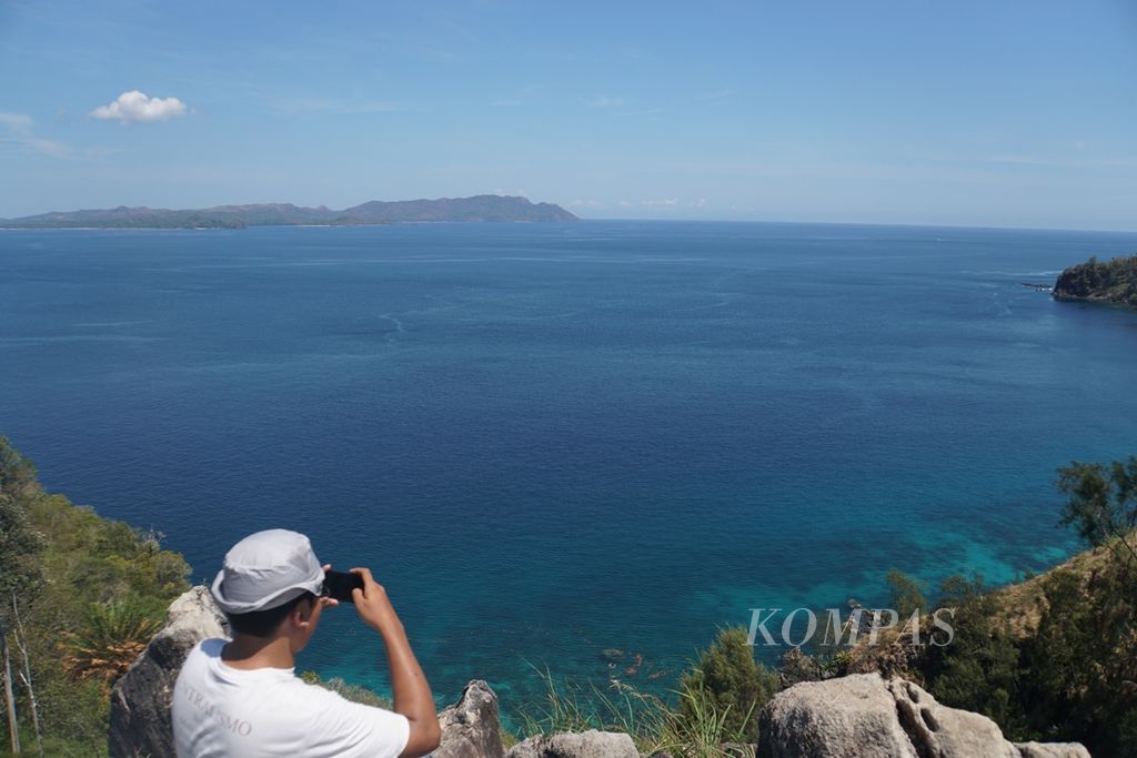 Wisatawan mengambil foto Laut Sulawesi dari puncak Bukit Pulisan di KEK Likupang, Sabtu (9/11/2019).