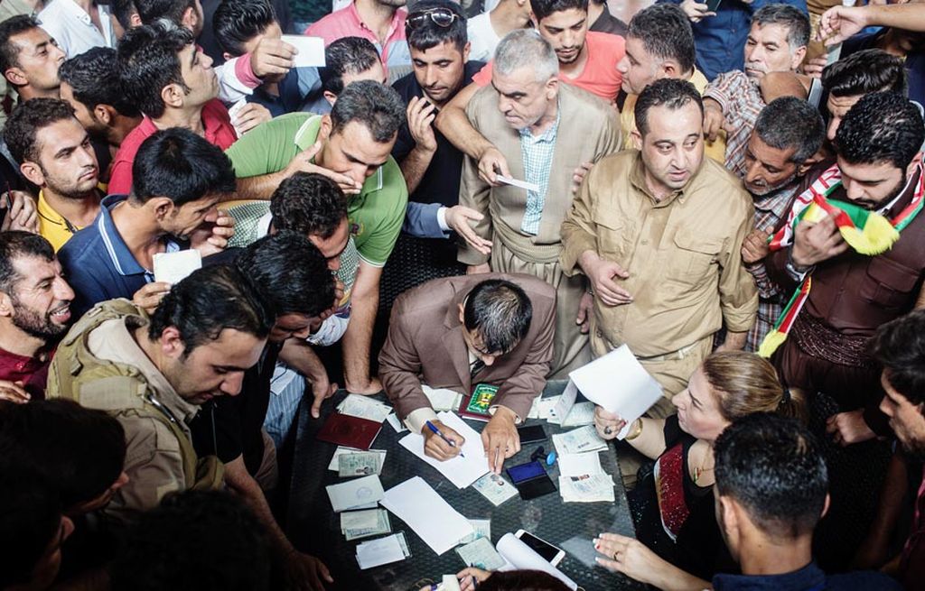 Warga Kurdistan Irak menunggu proses pengecekan identitas sebelum memberikan suara dalam referendum kemerdekaan di sebuah stadion yang digunakan sebagai tempat pemungutan suara di Erbil, Irak, Senin (25/9). Meski ditentang oleh Irak, Iran, Turki, dan Suriah, Kurdistan Irak  berkeras menggelar referendum.