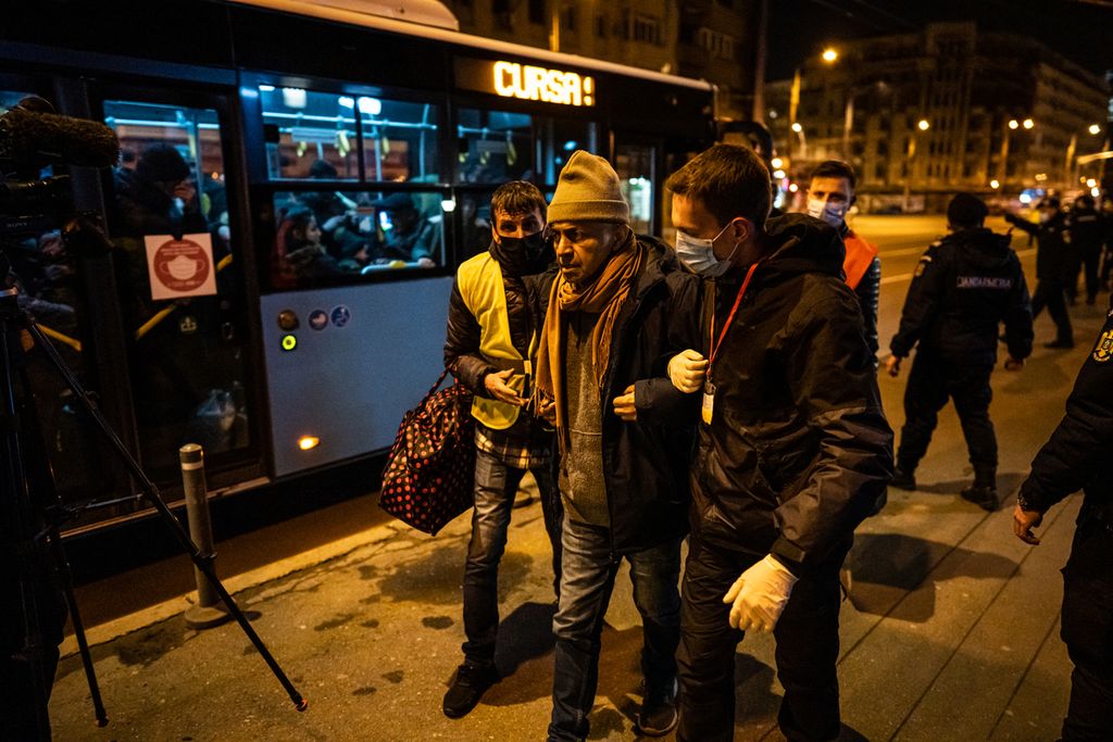 Sukarelawan membantu seorang pengungsi yang datang dari Ukraina saat tiba di Stasiun Kereta Api Utara di Bucharest, Romania, Jumat (4/3/2022). Pengungsi dari Ukraina berduyun-duyun ke Romania untuk menghindari invasi Rusia.