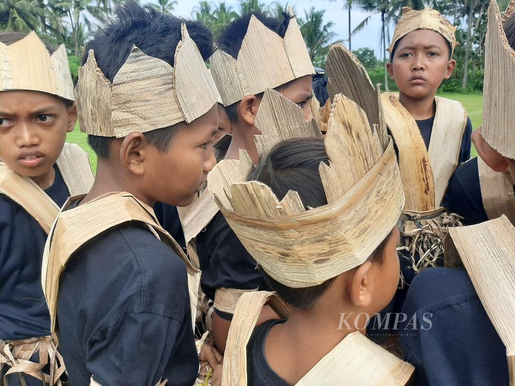 Sejumlah anak mengenakan kostum unik dengan aneka hiasan terbuat dari pelepah pisang, Sabtu (21/5/2022). Hiasan berbahan pelepah ini dipakai saat mereka menjadi suporter dalam pertandingan yang digelar dalam rangka Liga Pisang Borobudur, 21-25 Mei 2022.