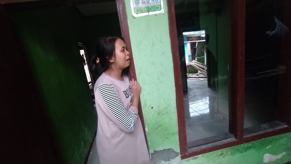 Siti Fatimah (27) berdiri di pintu rumahnya sembari menceritakan gempa yang menimpa rumahnya di Desa Pakuon, Sukaresmi, Cianjur, Jawa Barat, Sabtu (26/11/2022).