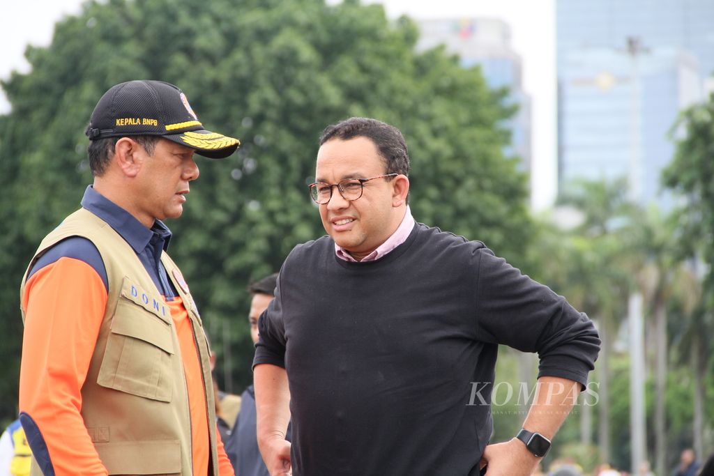 Kepala Badan Nasional Penanggulangan Bencana Doni Mordano dan Gubernur DKI Jakarta Anies Baswedan seusai meninjau banjir Jakarta dengan helikopter di Lapangan Monumen Nasional, Rabu (1/1/2020).