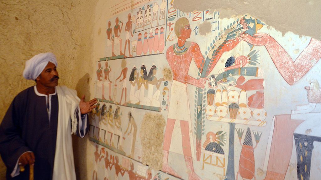Seorang pekerja Mesir berdiri di samping sebuah mural Mesir kuno yang baru ditemukan di makam "Kampp 161", di Nekropolis, Draa Abul Naga, di tepi Sungai Nil, Kota Luxor, Mesir, sekitar 650 kilometer arah selatan ibu kota Kairo, Mesir, Sabtu (9/12).