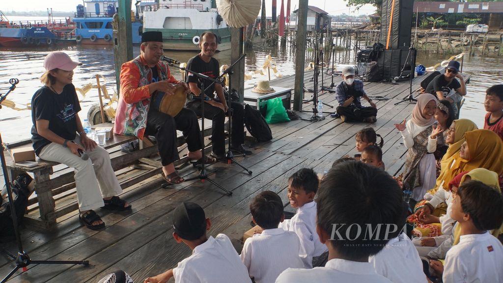 Seniman madihin, Ahmad Syarani, melantunkan syair madihin di depan anak-anak di Dermaga Pasar Terapung Muara Kuin, Banjarmasin, Kalimantan Selatan, Sabtu (9/9/2023).