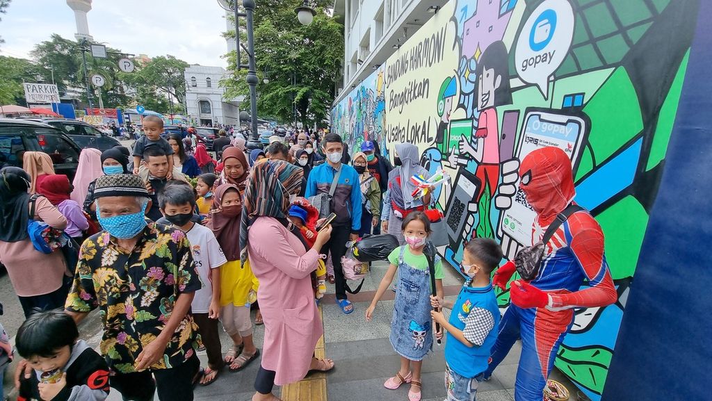 Sejumlah warga berfoto bersama pemain kostum di Jalan Asia Afrika, Kota Bandung, Jawa Barat, Minggu (2/1/2022).