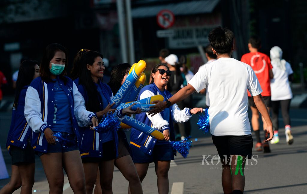 Tim penggembira memberikan semangat bagi peserta Semarang 10K Powered by Isoplus yang berlari menuju garis finis di Kantor Balai Kota Semarang, Jawa Tengah, Minggu (18/12/2022). 