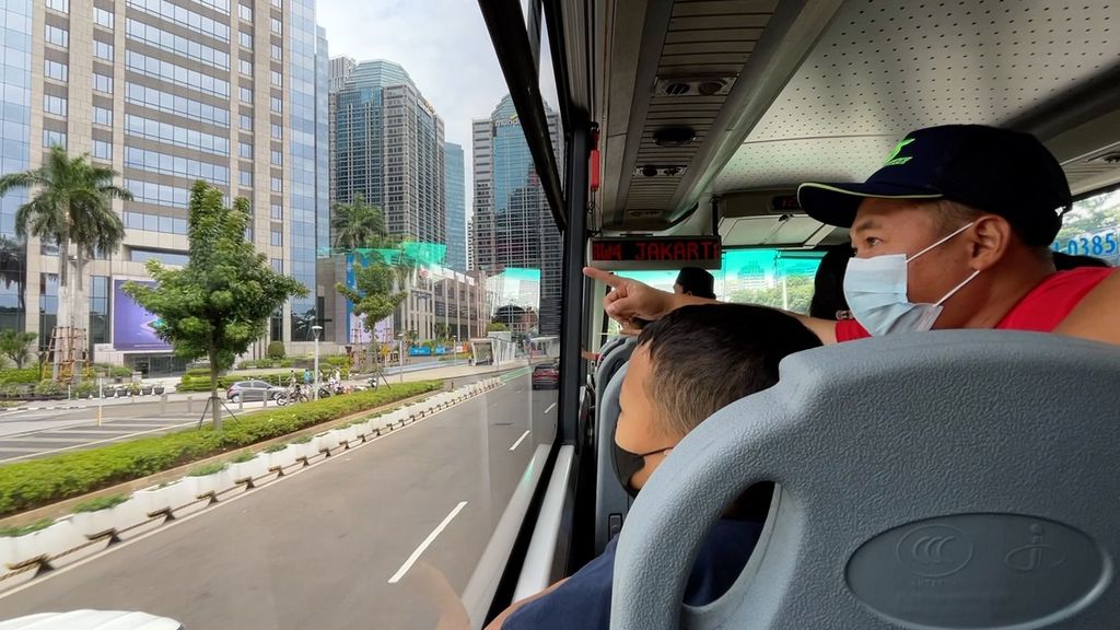 Penumpang melihat suasana gedung Jakarta dari dalam bus tingkat wisata menuju Bunderan Hi, Senayan, Jakarta, Selasa (3/5/2022)