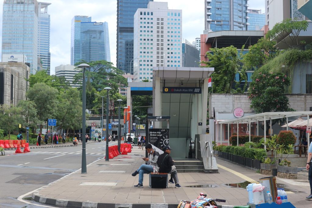 Two residents use a solar-powered charging station in the <i>transit oriented development</i> BNI Dukuh Atas MRT Station area, Central Jakarta, Friday (11/11/2022).
