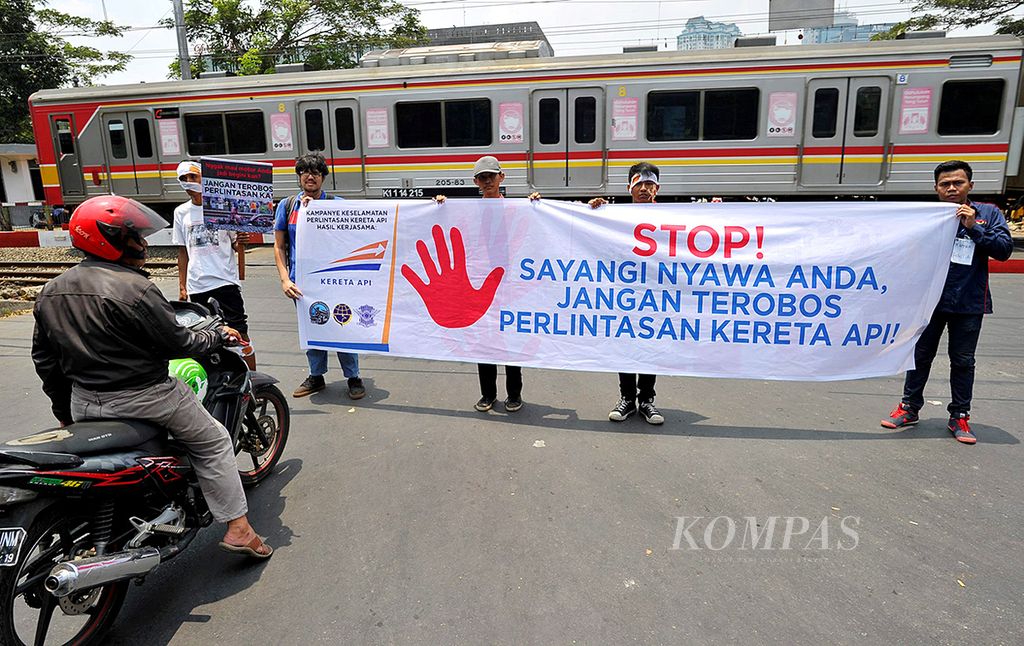 Anggota Indonesian Railway Preservation Society menggelar kampanye keamanan pelintasan sebidang kereta api di pelintasan Jalan Madiun, Menteng, Jakarta Pusat, Kamis (15/10/2015). 