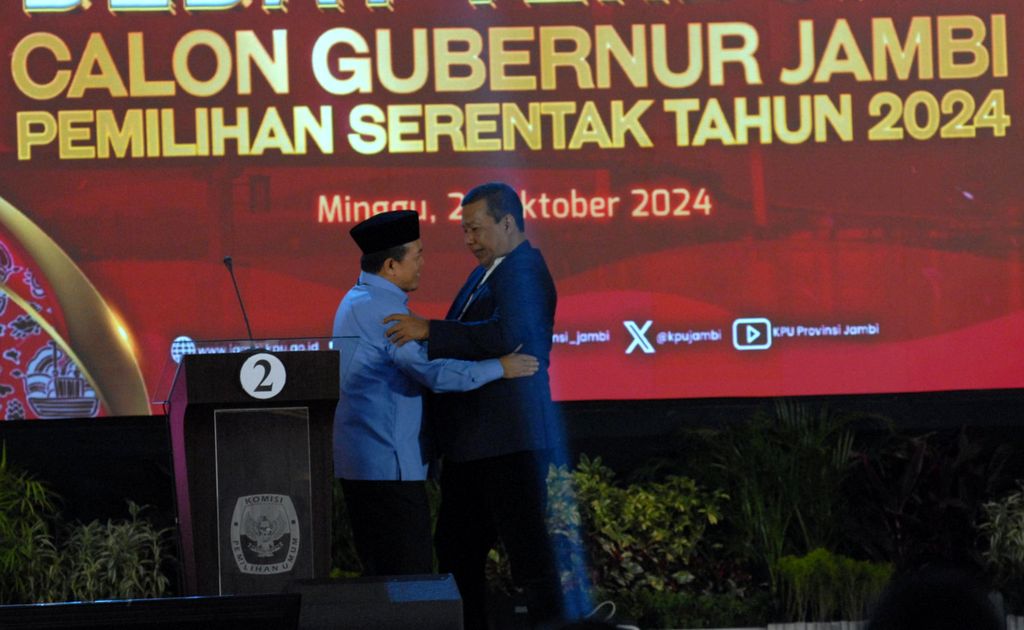 Dua calon gubernur Jambi, Al Haris (kiri) dan Romi Hariyanto, saling menyapa dalam Debat Terbuka yang diselenggarakan KPU Provinsi Jambi, Minggu (27/10/2024) malam. 