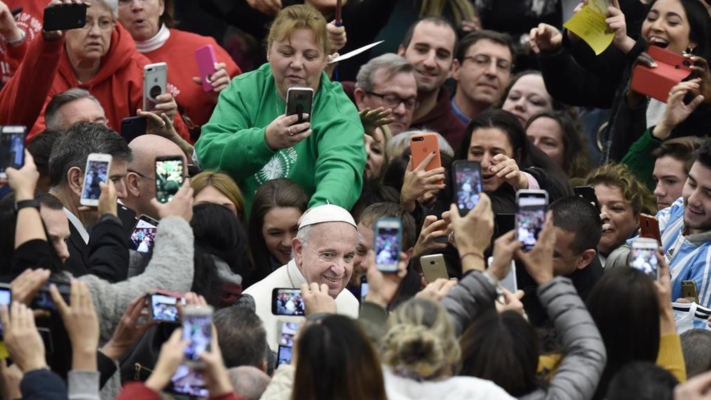 Sejumlah umat menggunakan telepon genggam mereka untuk memotret Paus Fransiskus yang tiba di aula Paulus VI, Vatikan, untuk menghadiri audiensi mingguan, 2 Januari 2019, di Vatikan.