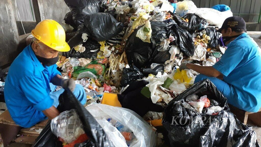 Pekerja di Rumah Kompos Tempat Pengolahan Sampah Terpadu (TPST) Kawasan Ubud di Desa Adat Padangtegal, Ubud, Gianyar, Jumat (5/7/2019), memisahkan sampah non-organik sesuai jenis sampahnya.