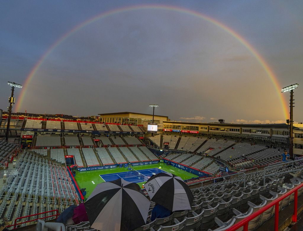 Spectators wait for the rain to stop while watching a rainbow during the ATP/WTA 1000 tennis tournament in Montreal, Canada, Thursday (10/8/2023), local time.  Rain postponed a number of tournament matches.