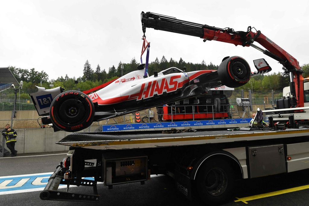 Panitia mengevakuasi mobil yang dikemudikan pebalap tim Haas, Kevin Magnusen, setelah mengalami kecelakaan saat sesi latihan bebas pertama balapan Formula 1 seri Belgia di Sirkuit Spa-Francorchamps, Spa, Jumat (26/8/2022).
