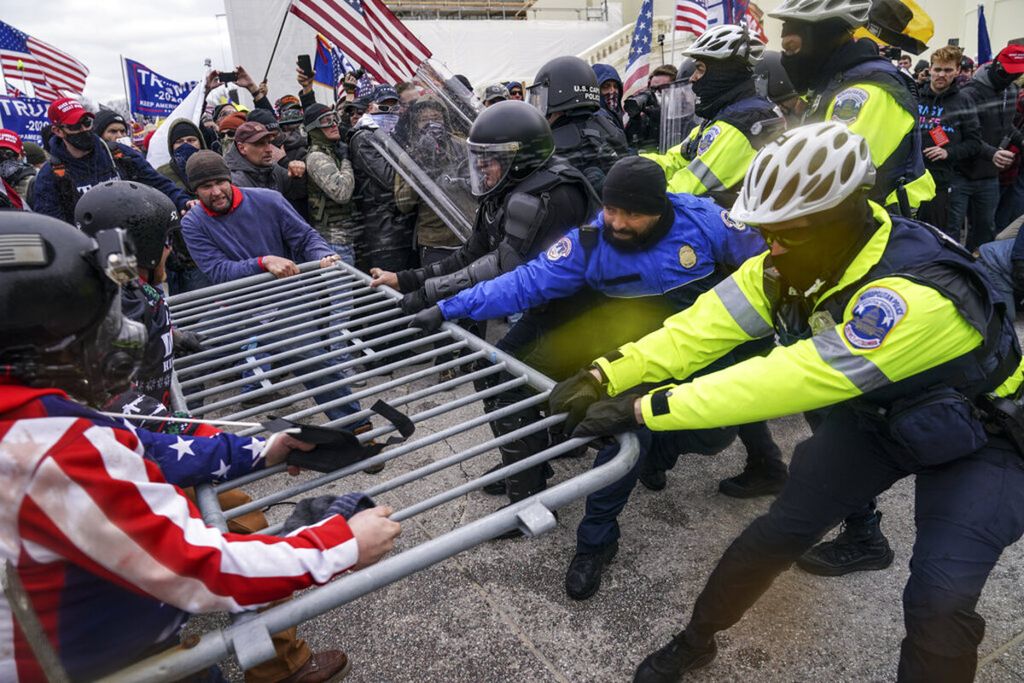 Pendukung Trump berusaha merobohkan dan menerobos pagar berikade penghalang agar dapat memasuki Gedung Capitol di Washington.