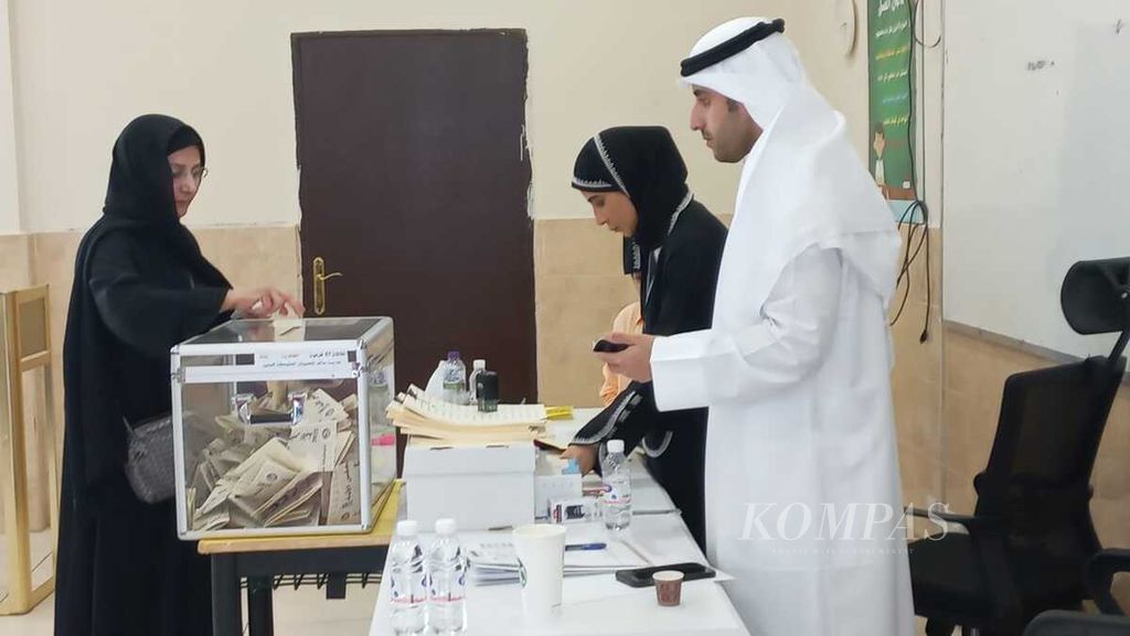 Seorang warga memasukkan kertas suara di sebuah kotak suara di TPS di Sekolah Menengah Atas Bibi al-Salem al-Sabah dalam pemilu legislatif di Dasma, Kuwait City, Kuwait, Selasa (6/6/2023).