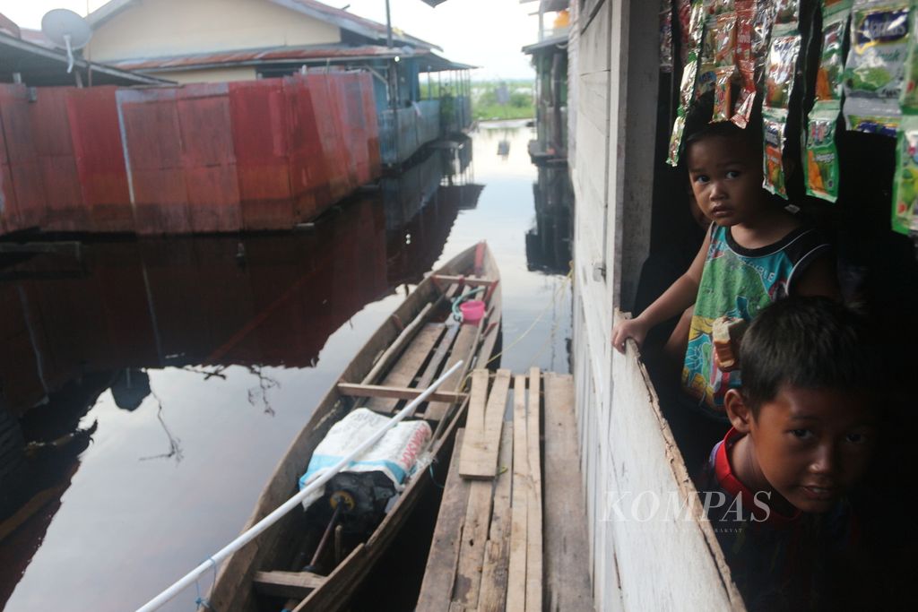 Warga Mendawai di Kota Palangkaraya beraktivitas di tengah banjir yang melanda selama lebih kurang satu minggu,  MInggu (27/11/2022). 