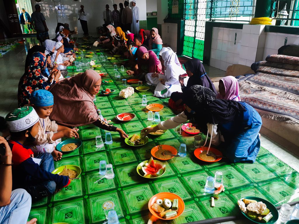 Suasana makan bersama bubur asyura di Masjid Mahmudiyah (Suro), Palembang, Sumatera Selatan, Sabtu (29/8/2020).
