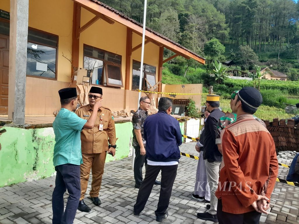 Penjabat Wali Kota Batu Aries Agung Paewai (memakai batik) meninjau lokasi retak di halaman SD-SMP Satu Atap di Dusun Brau, Desa Gunungsari, Kecamatan Bumiaji, Kota Batu, Jawa Timur, Minggu (19/3/2024).