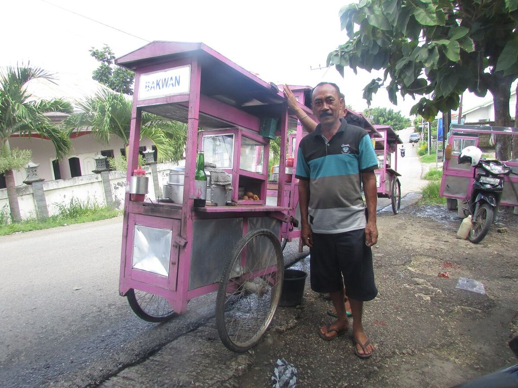 Nyaman (53) sedang menyiapkan anak buahnya berjualan bakwan dengan menggunakan gerobak keliling Kota Kupang, Jumat (11/2/2022).
