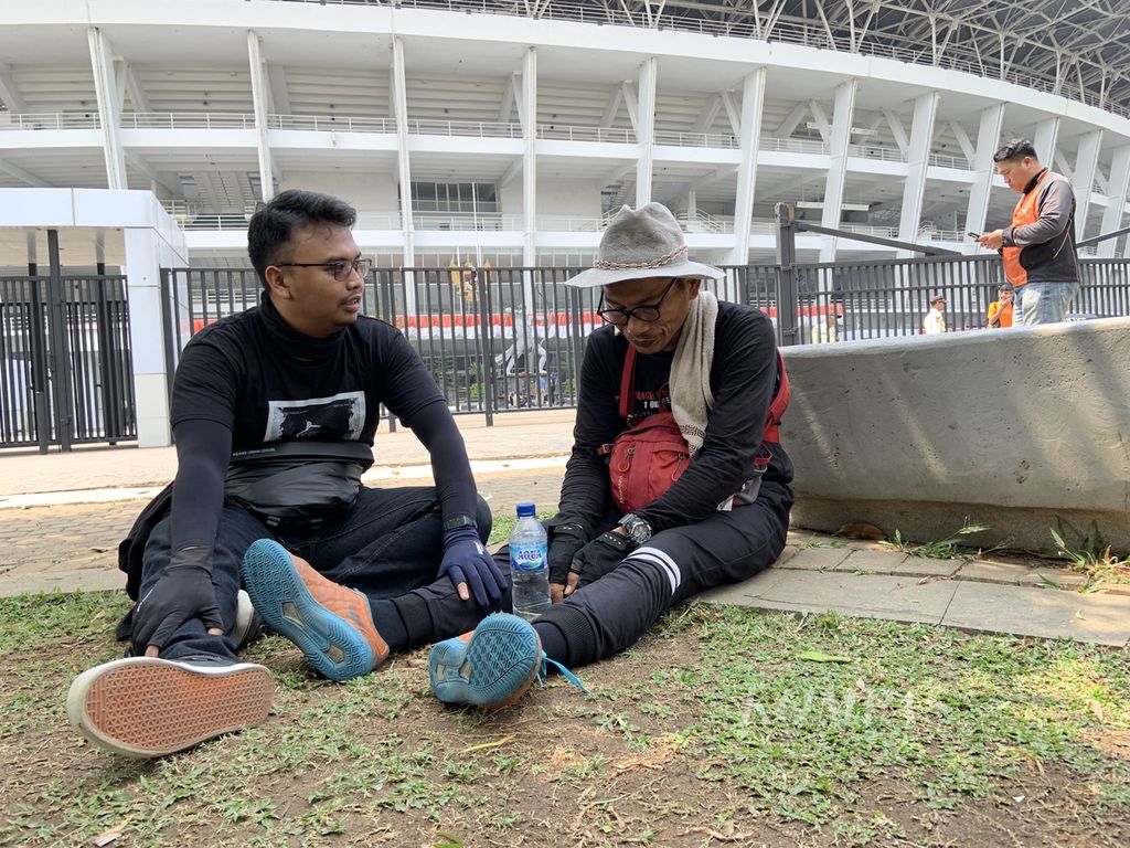 Miftahuddin Ramli (52) atau Midun tertunduk lemas usai dihentikan petugas keamanan Stadion Utama Gelora Bung Karno, Jakarta, saat hendak membawa masuk sepeda dengan keranda di bagian belakangnya. 