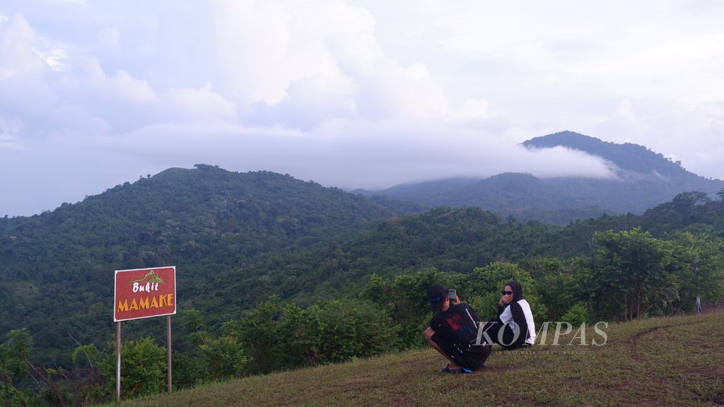 Pengunjung berfoto di puncak Bukit Mamake, Desa Sarang Tiung, Kecamatan Pulau Laut Sigam, Kabupaten Kotabaru, Kalimantan Selatan, Rabu (6/7/2022). 