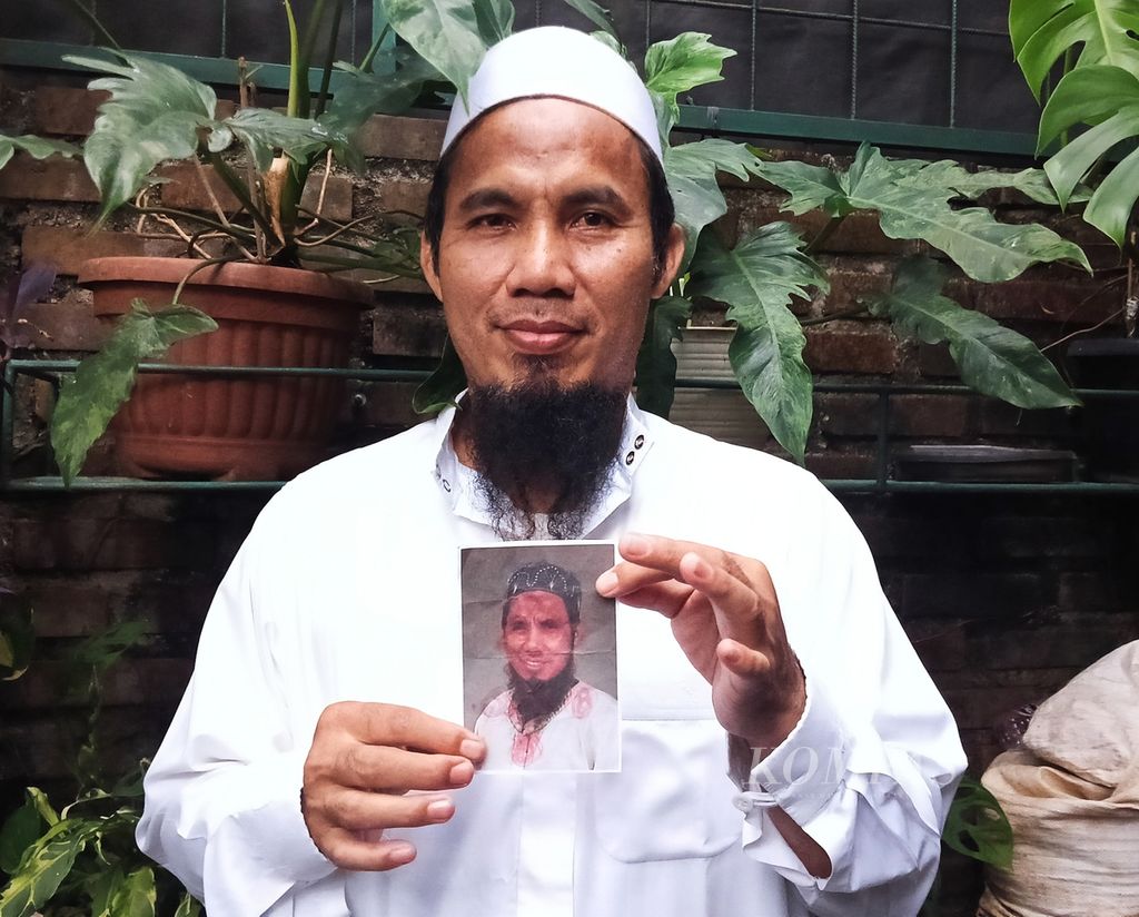 Egy Abdul Gani (54), warga Kampung Sawah, Ciputat, Tangerang Selatan, menunjukkan foto dirinya yang ditemukan di rumah Heriyadi AS (67), Rabu (6/3/2024).
