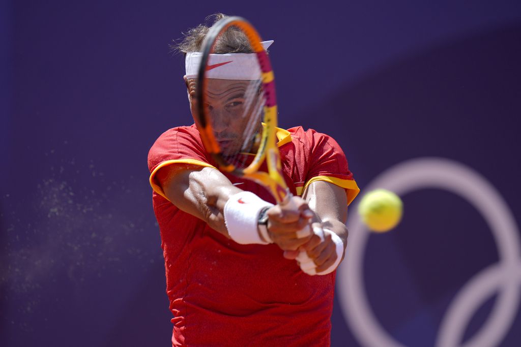 Rafael Nadal (Spanyol) memukul bola ke arah Novak Djokovic (Serbia) dalam pertandingan tenis babak kedua Olimpiade Paris 2024 di Stadion Roland Garros, Paris, Perancis, Senin (29/7/2024). 