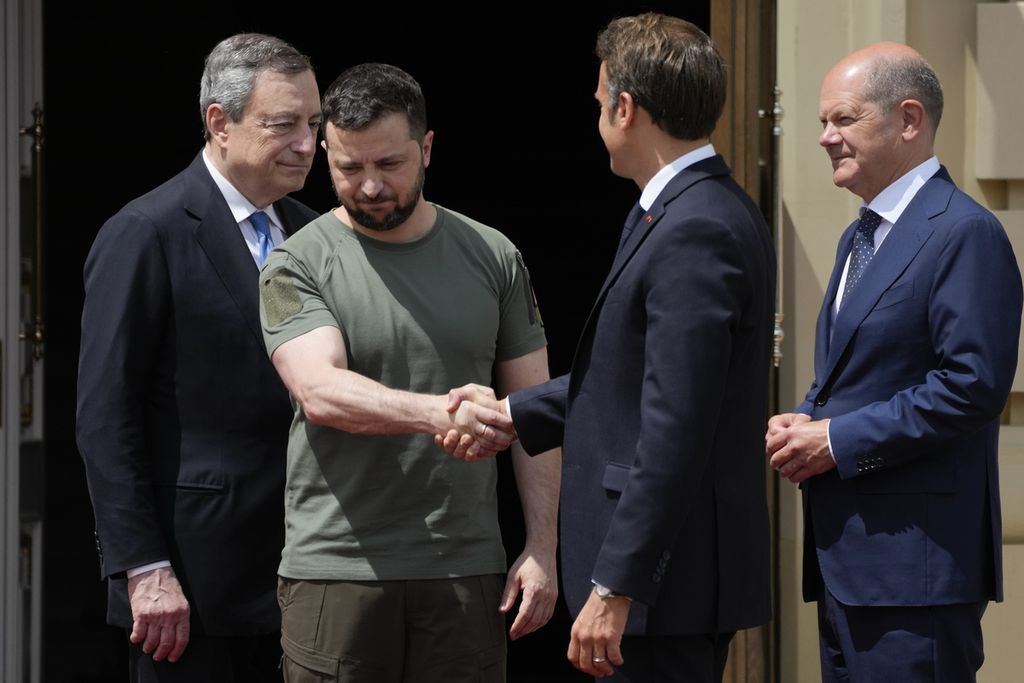 Presiden Ukraina Volodymyr Zelenskyy (kedua dari kiri) berjabat tangan dengan Presiden Perancis Emmanuel Macron, sementara Perdana Menteri Italia Mario Draghi (kiri) dan Kanselir Jerman Olaf Scholz berdiri di samping mereka di Istana Mariyinsky Palace, Kyiv, Ukraina, Kamis (16/6/2022). 