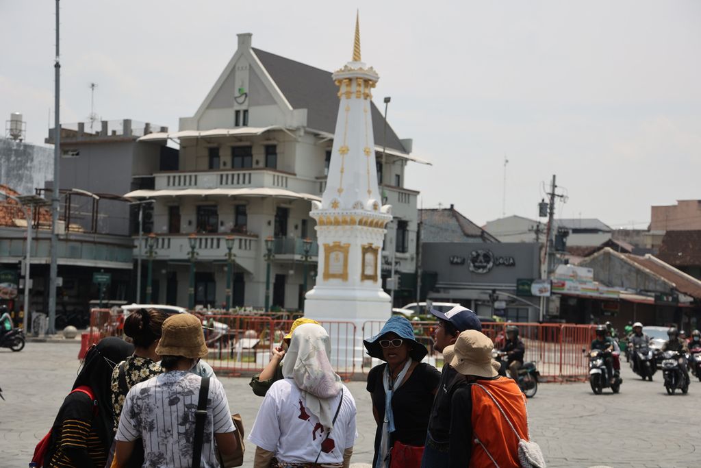 Peserta Jogja World Heritage Walk mendengarkan penjelasan saat mengunjungi perempatan Tugu, Yogyakarta, Senin (5/9/2022). Kegiatan yang berlangsung sepekan ini mengajak masyarakat mengenal lebih dekat sumbu filosofi Yogyakarta yang, antara lain, terdiri dari Tugu Pal Putih, kawasan Malioboro, Keraton Yogyakarta, dan bangunan cagar budaya Panggung Krapyak. Hal ini merupakan bagian upaya pengajuan sumbu filosofi Yogyakarta kepada UNESCO agar diakui sebagai salah satu warisan dunia.