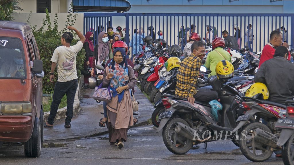 Sejumlah buruh keluar dari area pabrik saat jam pulang kerja di Kawasan Industri Batamindo, Batam, Kepulauan Riau, Selasa (22/9/2020).