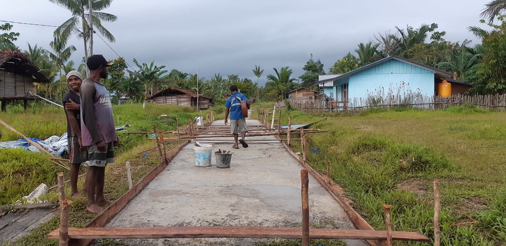 Jalan aspal yang dibangun menggunakan dana desa di Kampung Sinimburu, Kabupaten Boven Digoel, Papua, Minggu (8/3/2020). Penggunaan dana desa diprioritaskan untuk pembangunan infrastruktur dasar dan pemberdayaan warga.