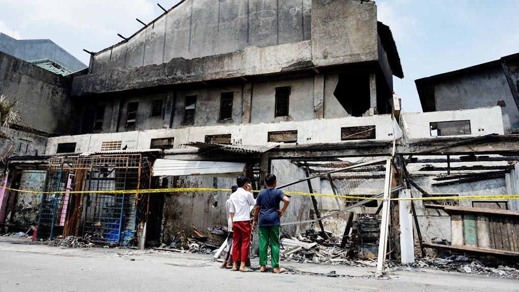 Anak sekolah melihat sisa-sisa kebakaran yang melanda 11 kios dan satu rumah di Jalan Pedongkelan Raya, Jakarta Barat, Jumat (2/2). Kebakaran itu menewaskan empat penghuni rumah.